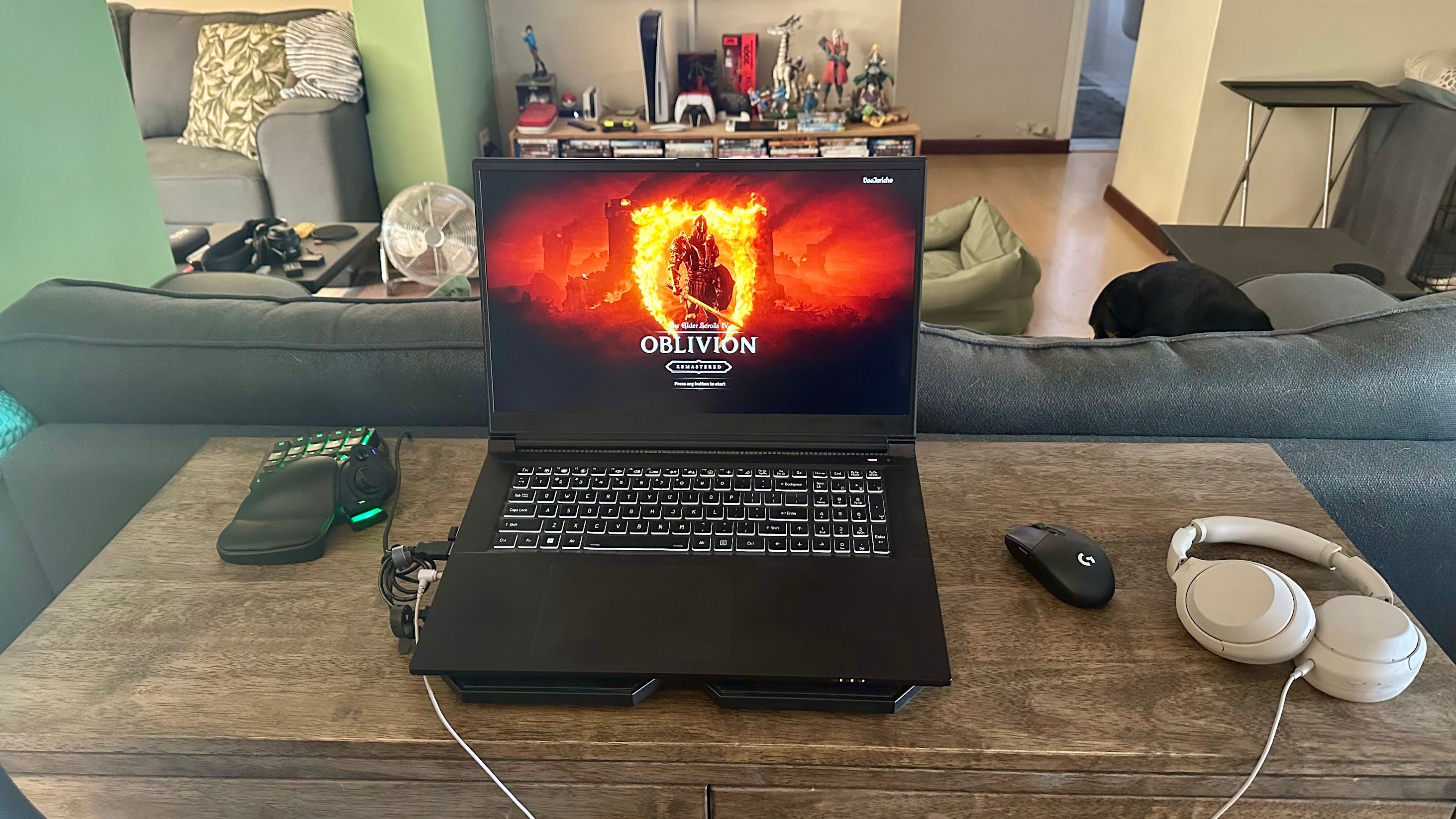 Why 1TB Of Storage Is No Longer Enough For A Gaming Laptop A Gaming Laptp On A Cooling Pad With A One Handed Keyboard To The Left 