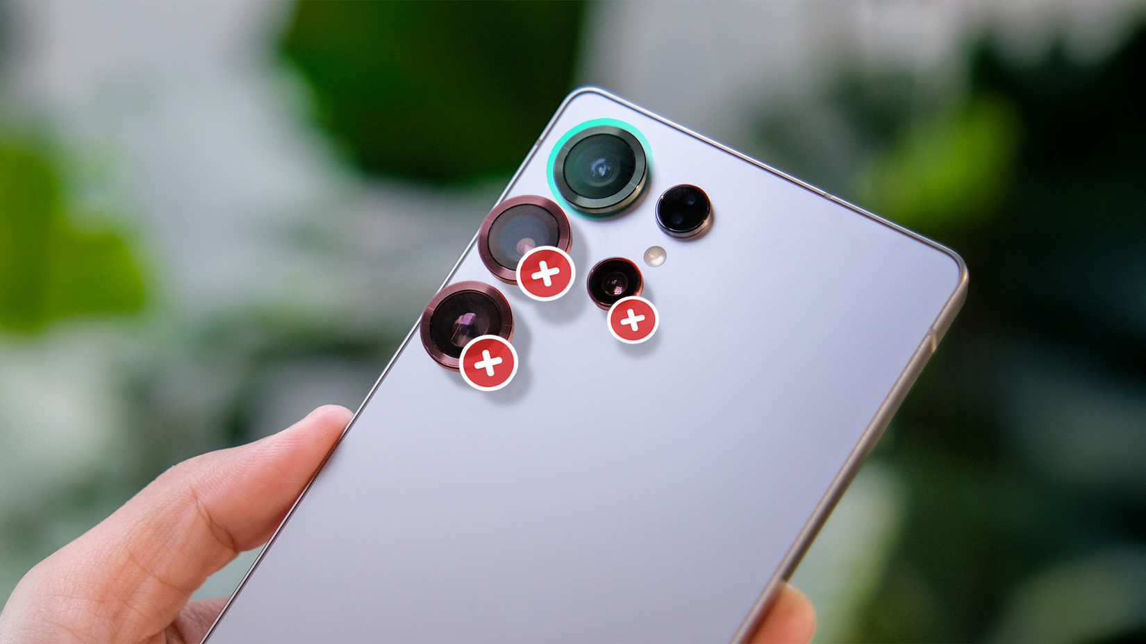 A hand holding a smartphone with three cameras crossed out.