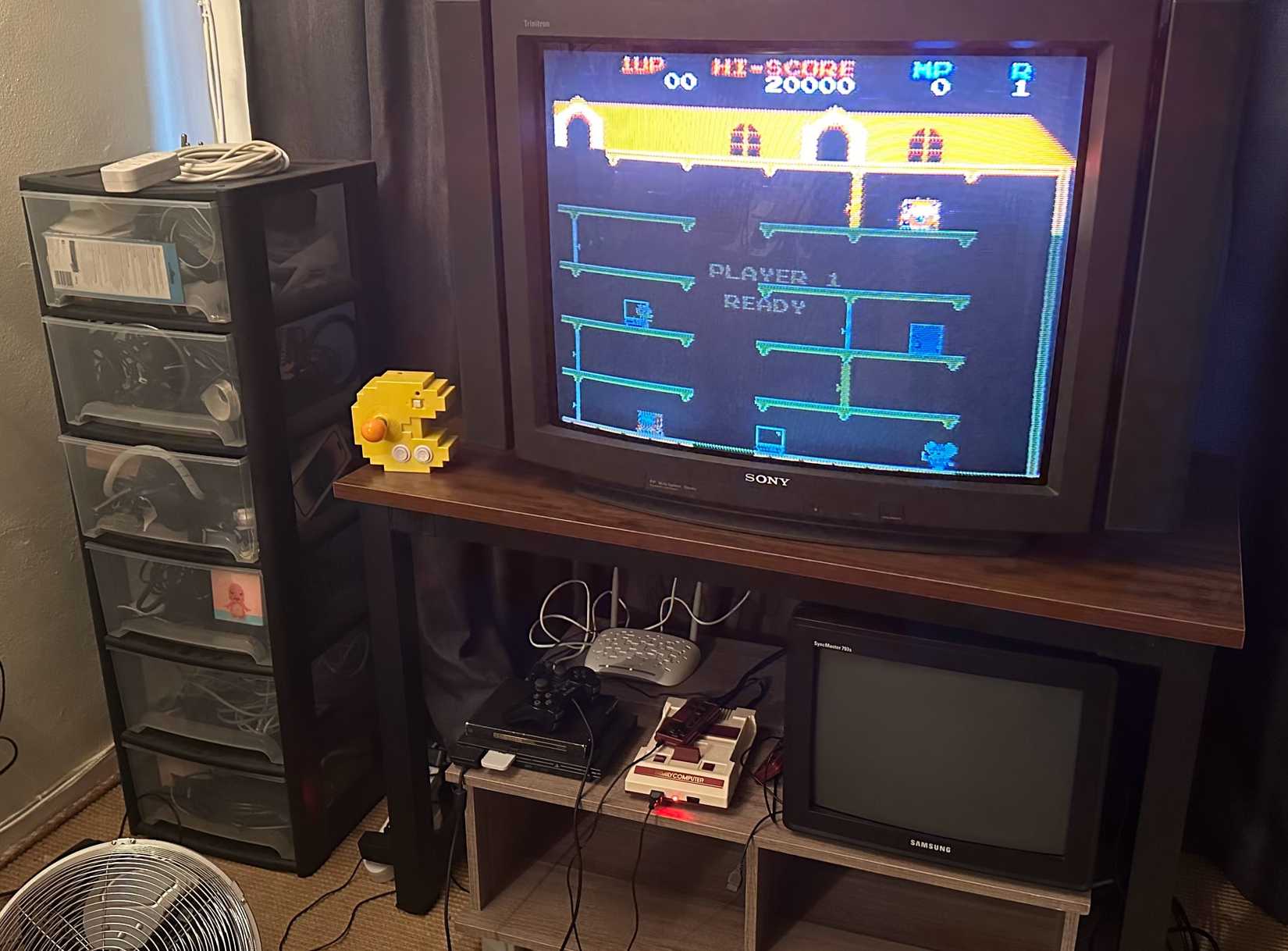 A plastic filing cabinat next to a CRT TV.