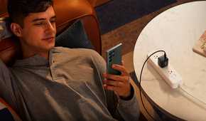 Anker 313 being used to charge a phone while someone uses it.