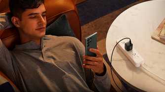 Anker 313 being used to charge a phone while someone uses it.