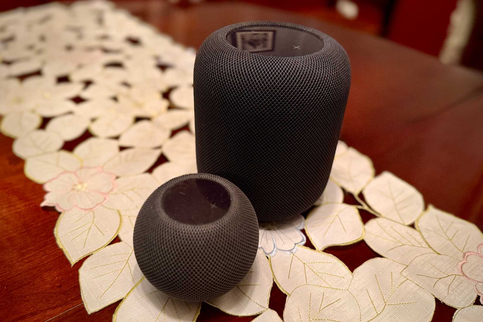 O topo de um HomePod preto e HomePod Mini.