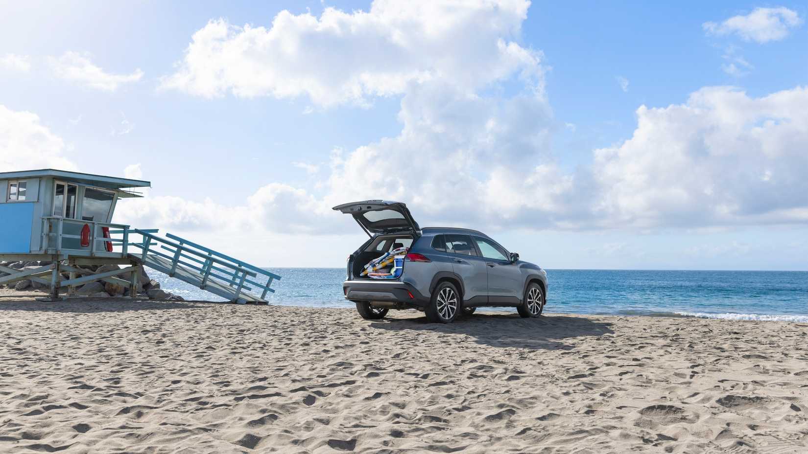 Foto 3/4 traseira de um Corolla Cross Hybrid 2025 com o porta-malas aberto