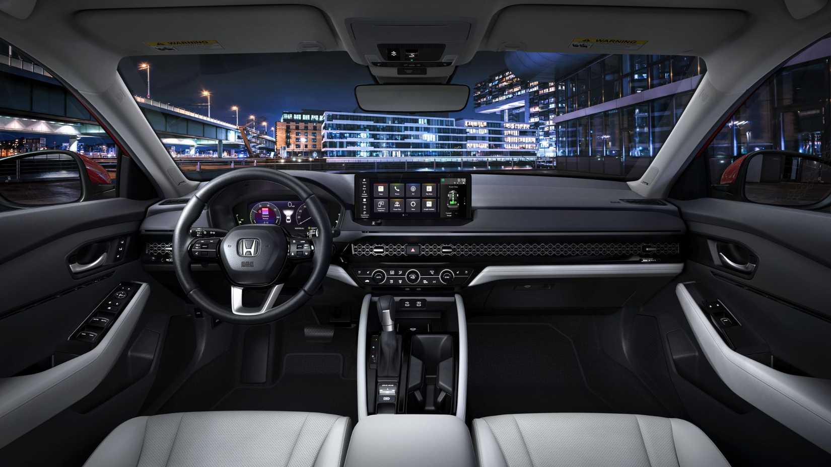 Shot of inside the cabin of a 2023 Honda Accord, showing the front seats, steering hweel, and infotainment screen,