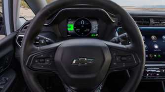 Close-up shot of the steering wheel in a 2022 Chevrolet Bolt EV, showing the digital instrument cluster and infotainment screen.