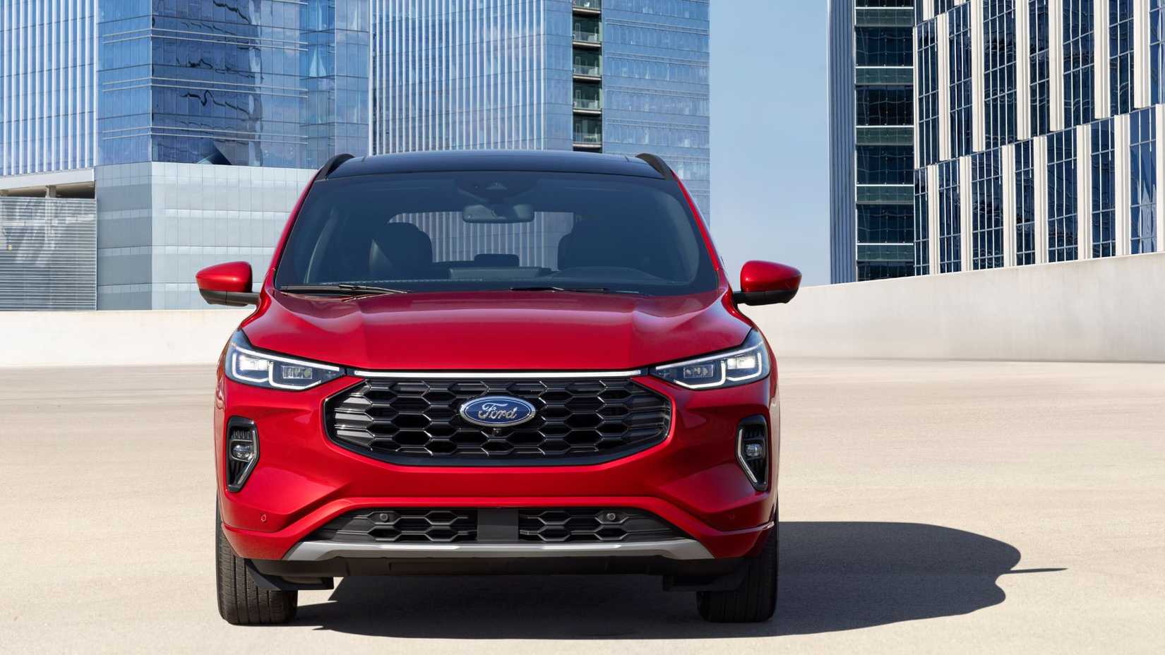 Static front-end shot of a red 2023 Ford Escape ST-Line Elite with high-rise buildings in the background.