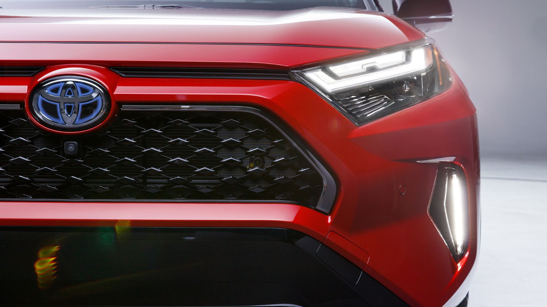 Close-up shot of the front end of a red 2024 Toyota RAV4 Prime XSE.