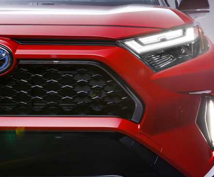 Close-up shot of the front end of a red 2024 Toyota RAV4 Prime XSE.