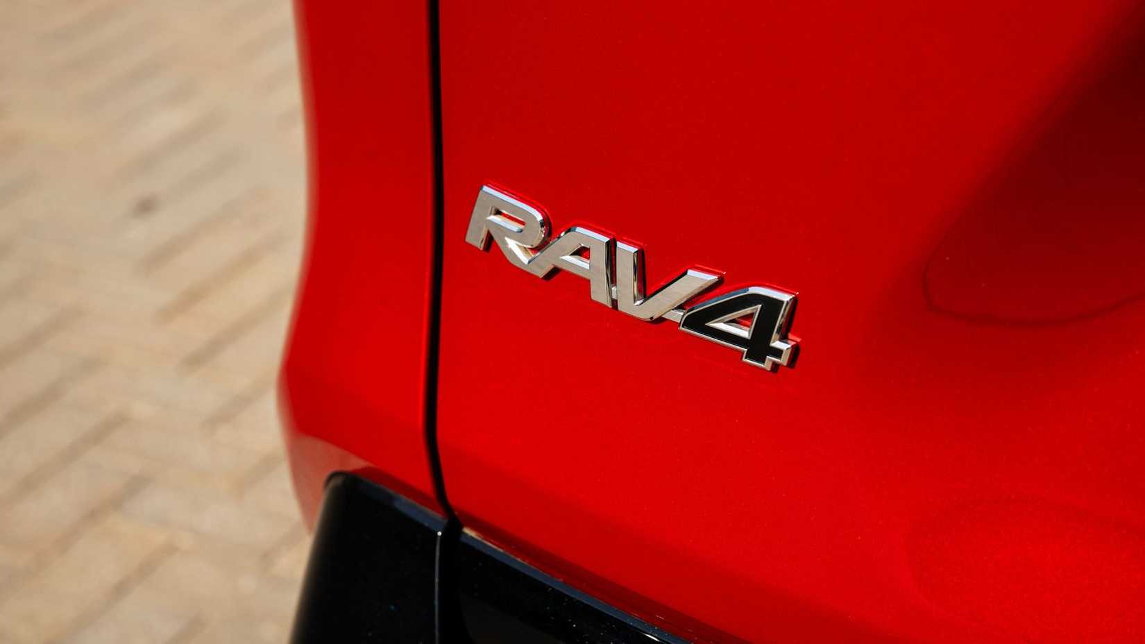 Close-up shot of the 'RAV4' badging on the rear of a red 2025 Toyota RAV4 PHEV XSE.