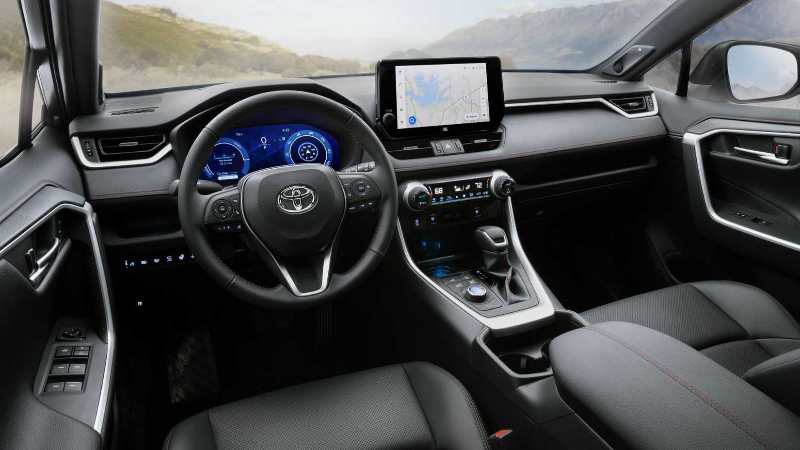 Foto do interior da cabine de um Toyota RAV4 PHEV XSE 2025, mostrando os bancos dianteiros, o volante e a tela de infoentretenimento.