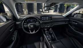 Shot inside the cabin of a 2023 Honda Accord Touring, showing the front seats, steering wheel, and infotainment screen.