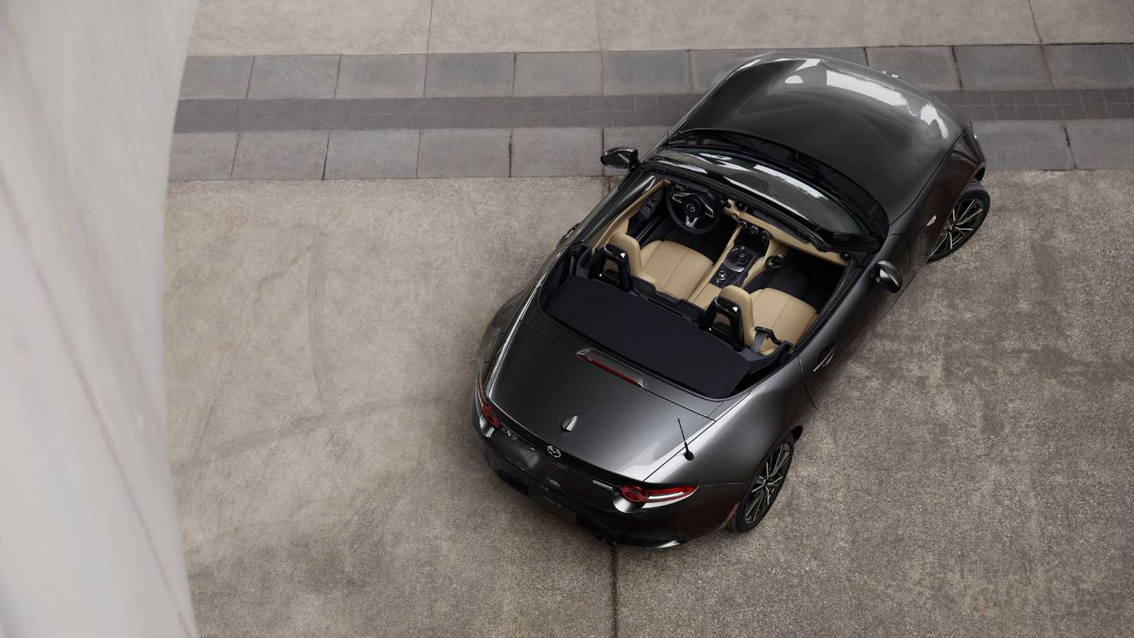 Overhead shot of a gray 2024 Mazda MX-5 with its roof down. 