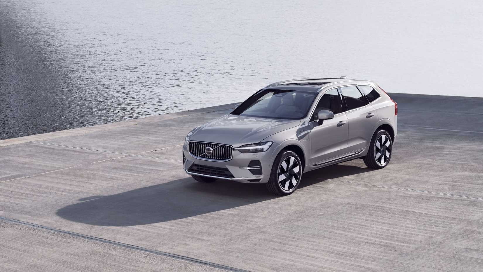 Static front 3/4 shot of a 2025 Volvo XC60 PHEV parked next to water.