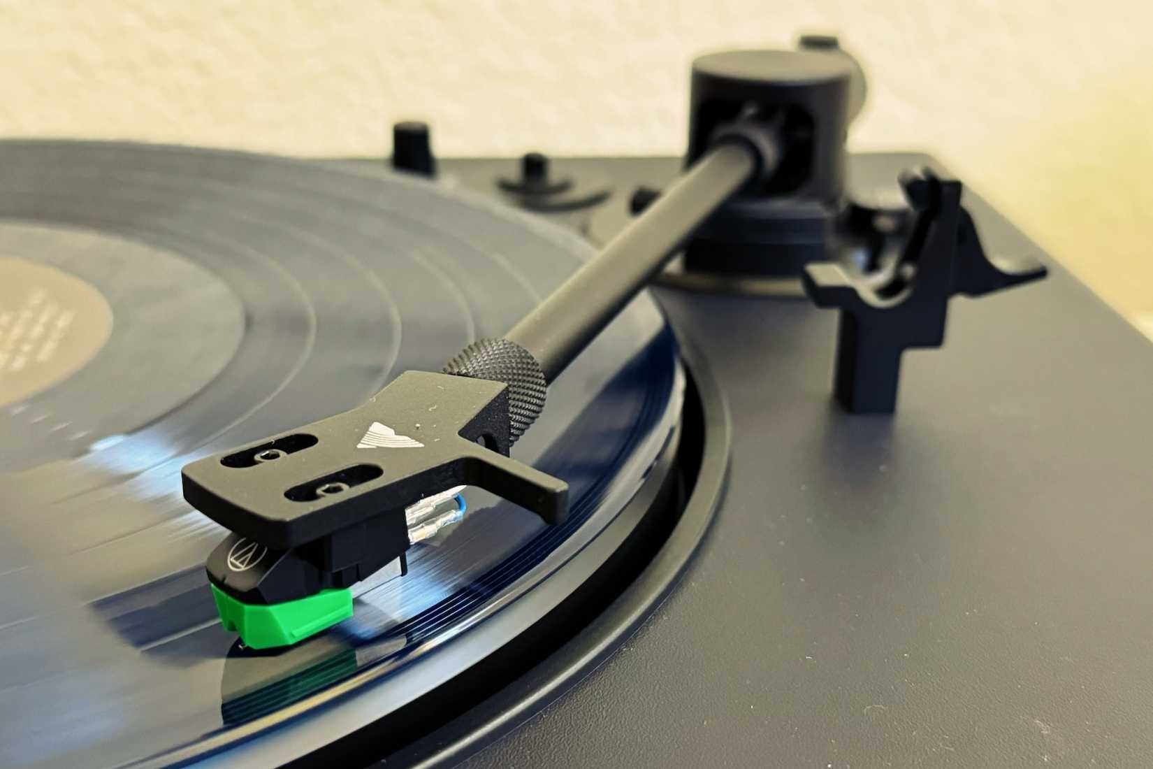 A stylus attached to a tone arm, running on a vinyl record.