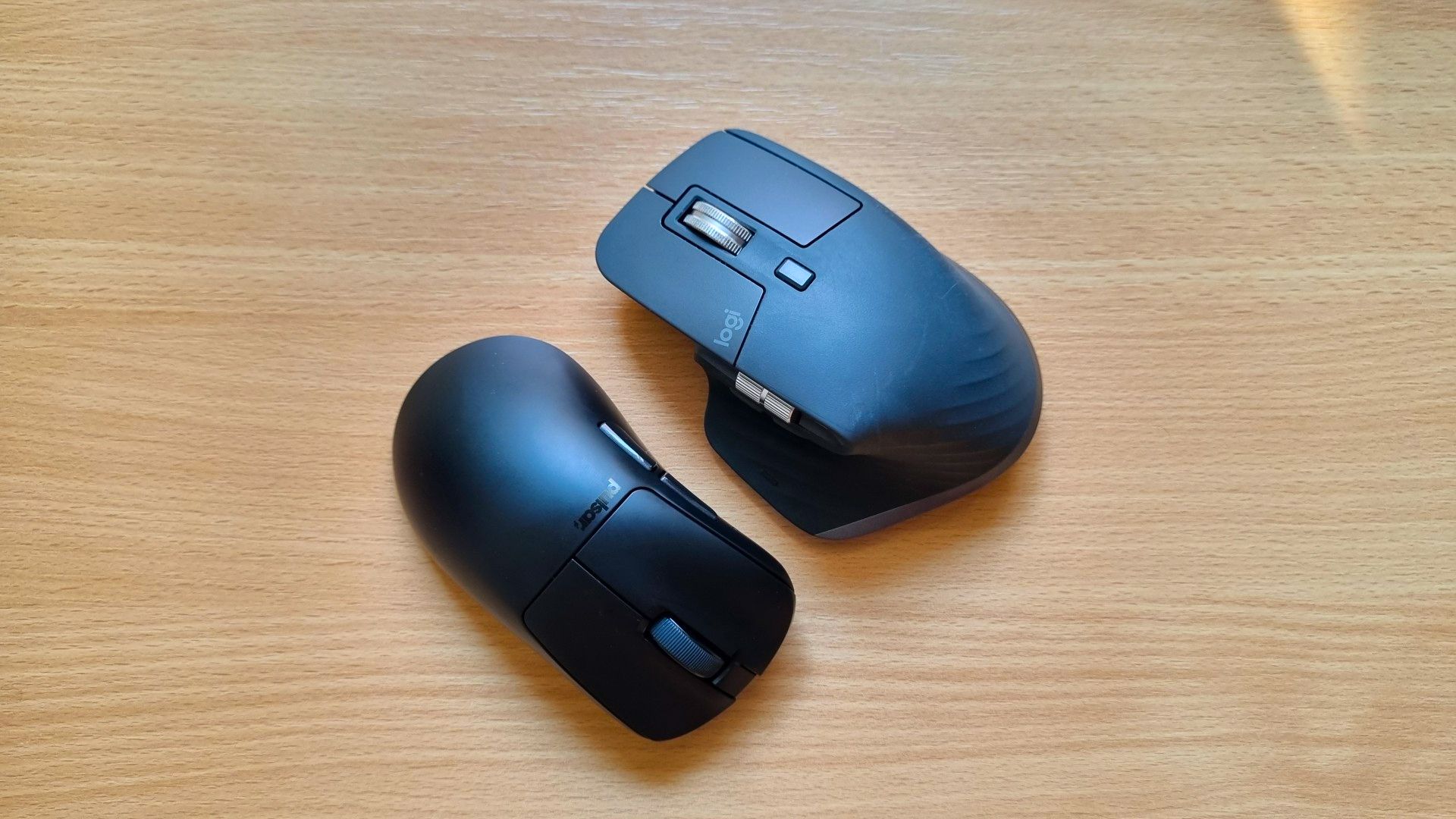 A Pulsar Xlite V3 and a Logitech MX Master 3S lying next to one another.