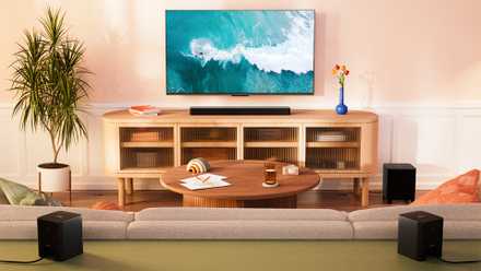 An Amazon Fire TV Soundbar Plus with built-in subwoofer under a TV mounted on a wall.