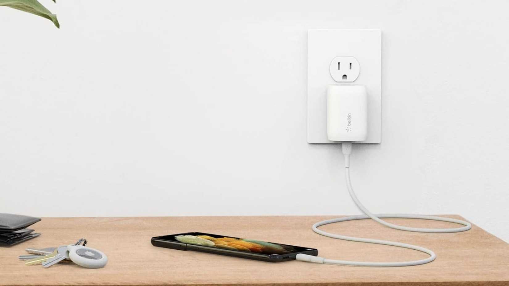 Balkin wall charger with USB-C charging a phone on a desk.