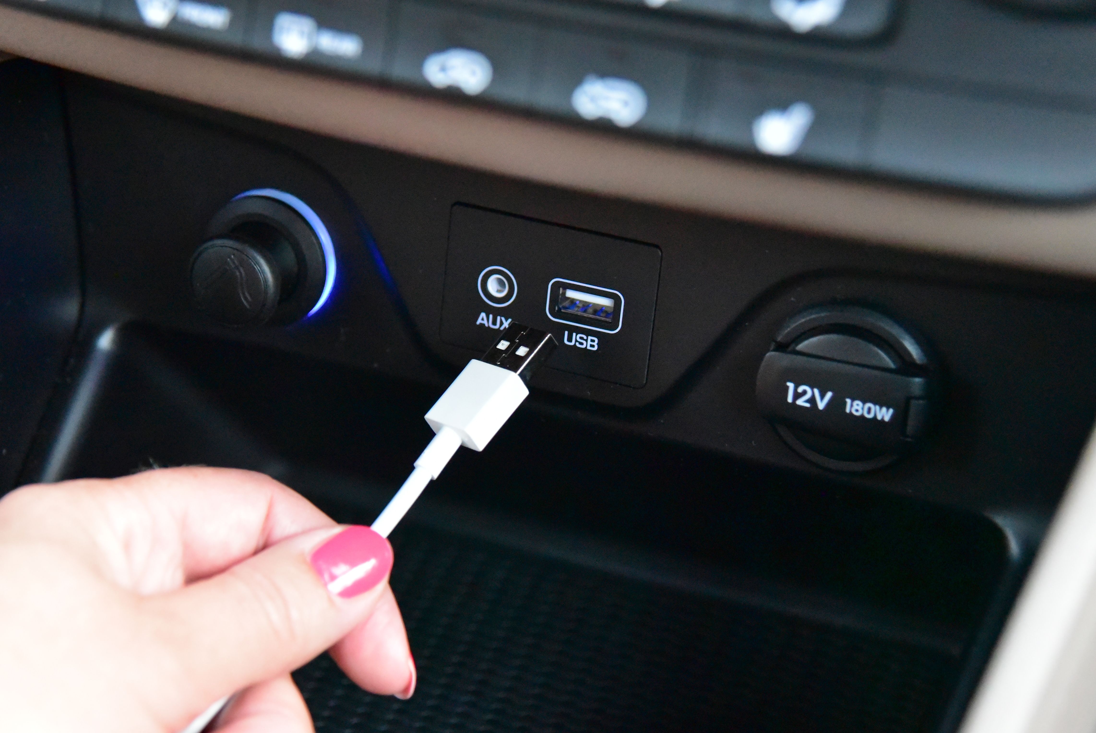 Manually plug a USB cable into a car dashboard port