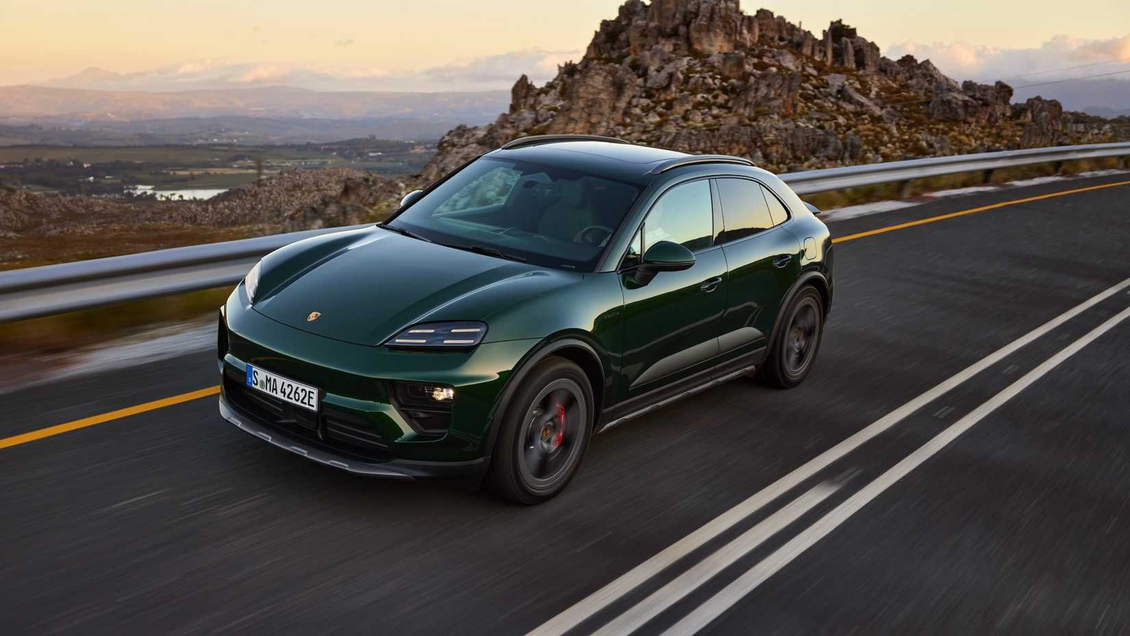 Elevated front quarter view of the Porsche Macan EV driving.