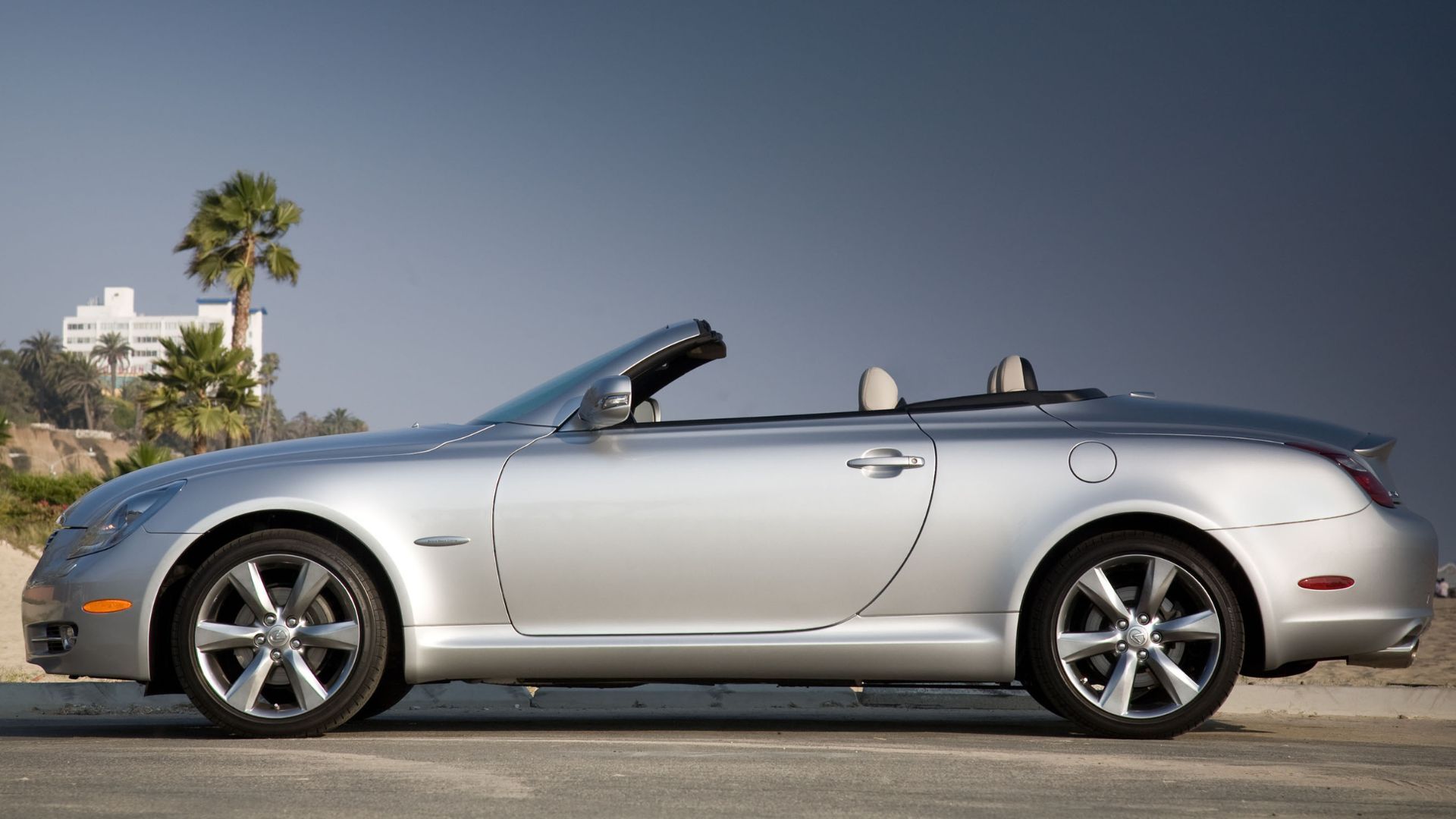 Static side profile shot of a silver 2010 Lexus SC 430 parked on a beach.