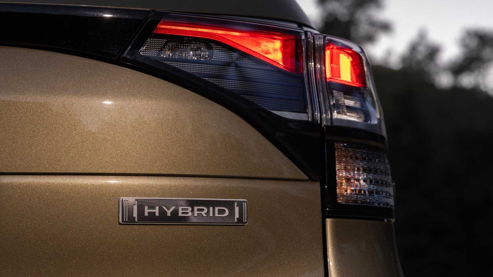 Close-up of the 'Hybrid' bag on the tailgate of a green 2025 Subaru Forester Hybrid.