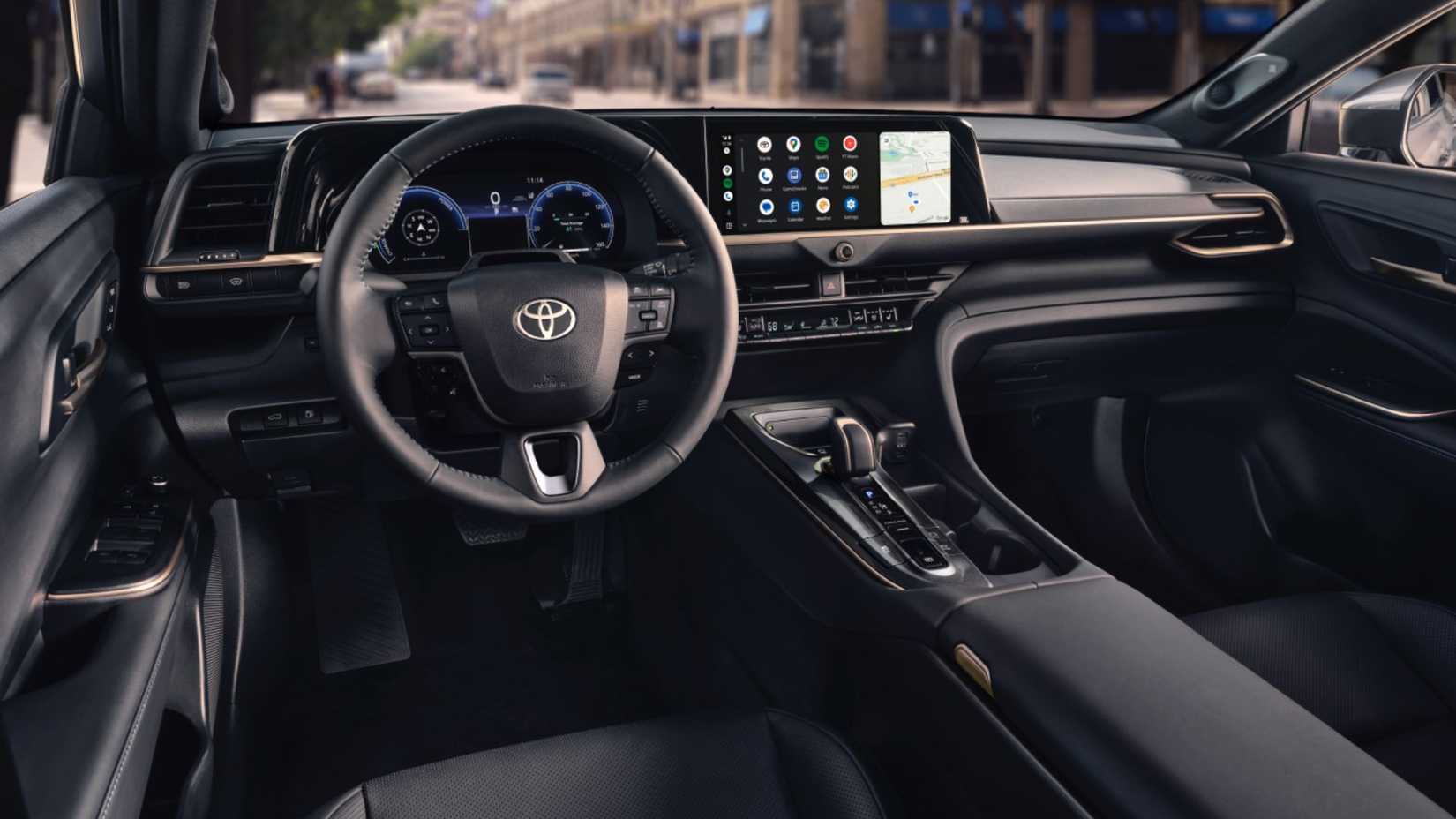 Shot inside the cabin of a 2026 Toyota Crown, showing the front seats, steering wheel, and infotainment screen.