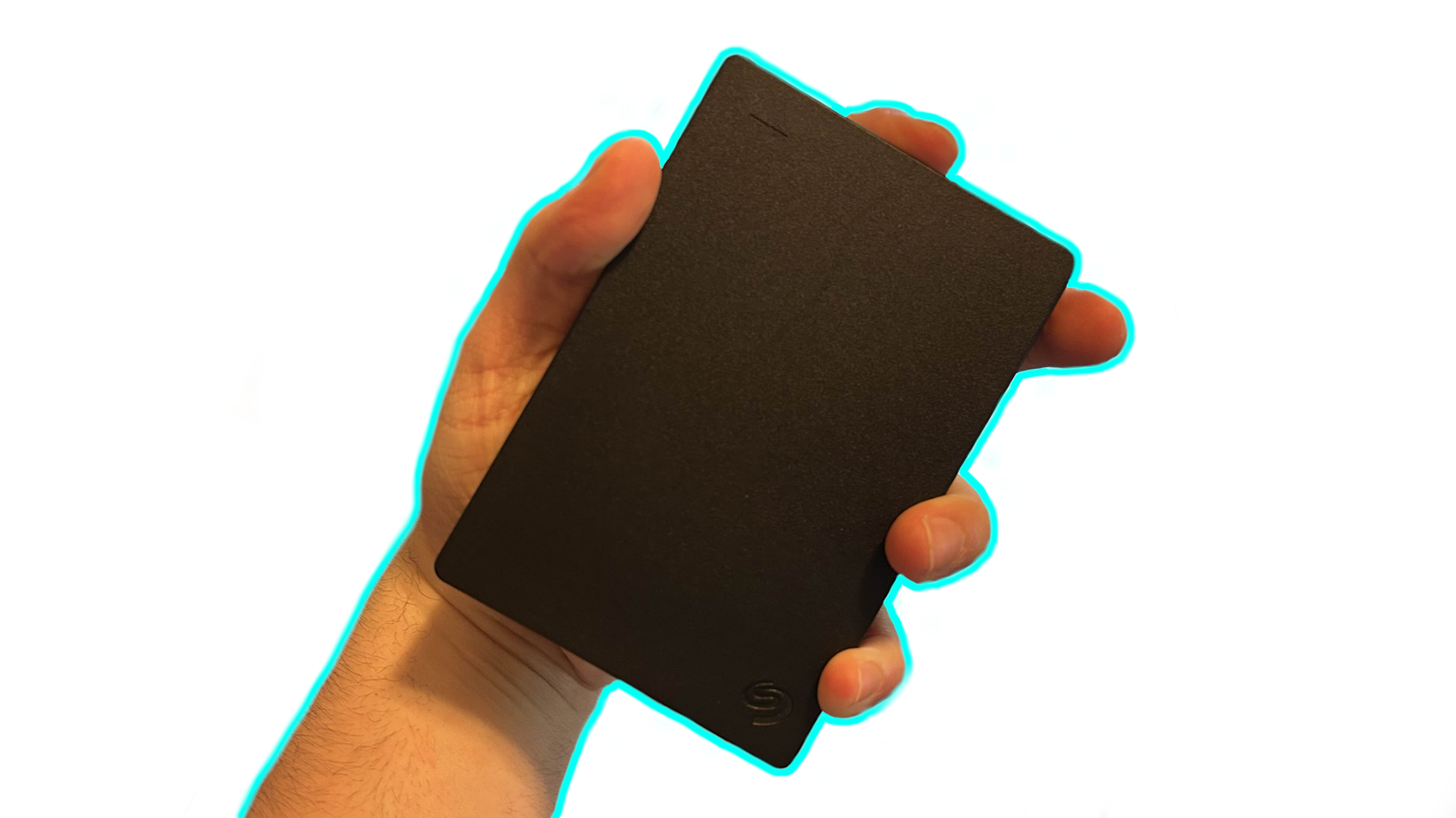 a hand holding up an external hard drive