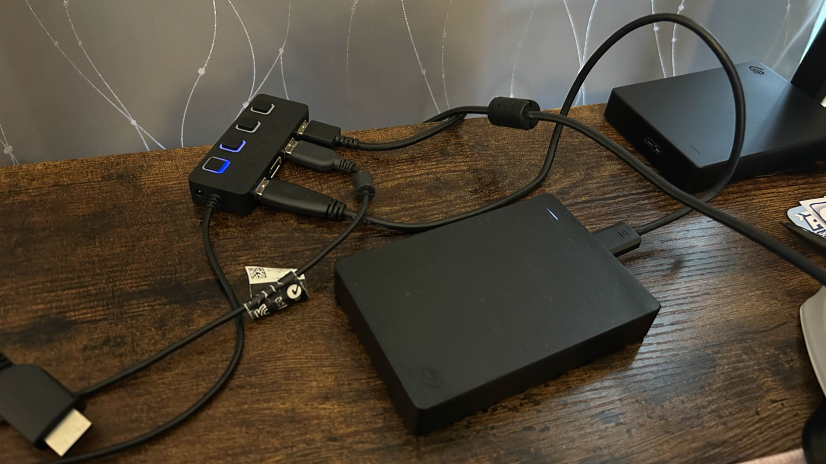 a seagate portable external harddrive connected to a usb hub connected with other wires around it