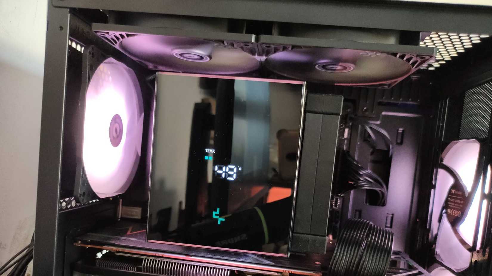 Um cooler de ar para CPU com display digital cercado por exaustores superiores e traseiros.