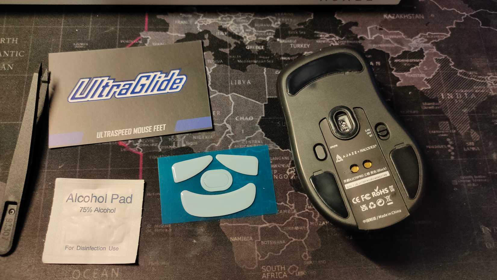 The Ajazz AJ179 Pro mouse with new mouse skates next to it.