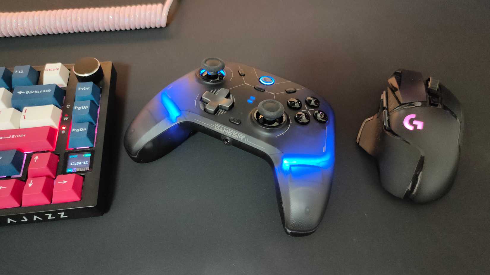 O controlador GameSir Cyclone 2 entre um mouse Logitech G502 e um teclado mecânico.