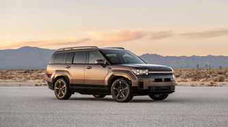 Static front 3/4 shot of a bronze 2025 Hyundai Santa Fe Hybrid parked on a salt plain with mountains in the background.