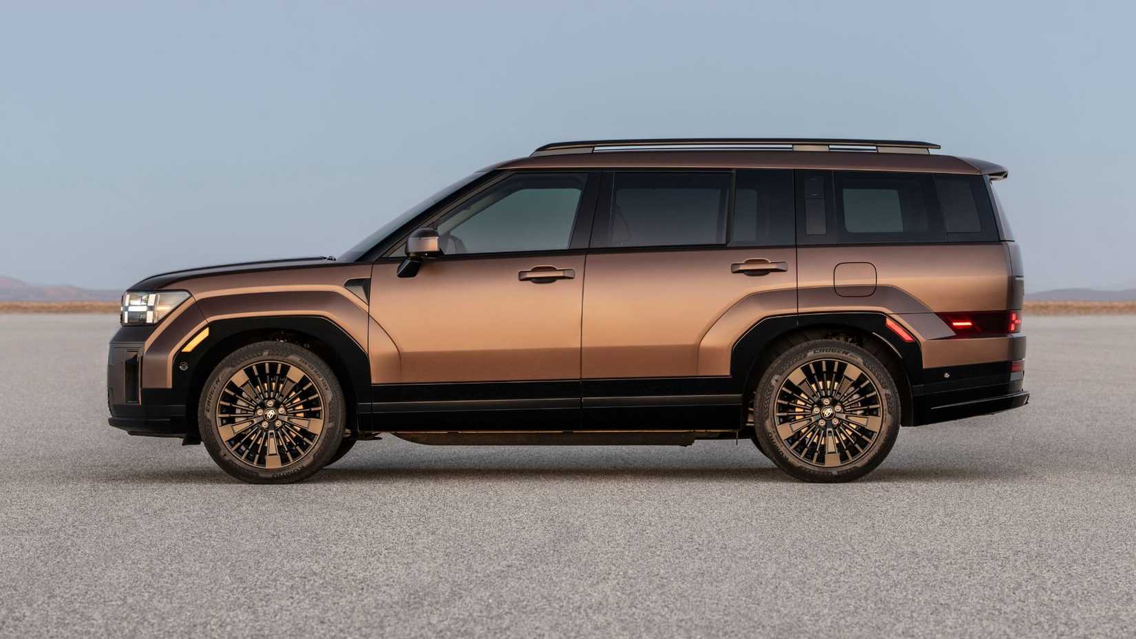 Side profile static shot of a bronze 2025 Hyundai Santa Fe Hybrid parked on the Salt Flats.