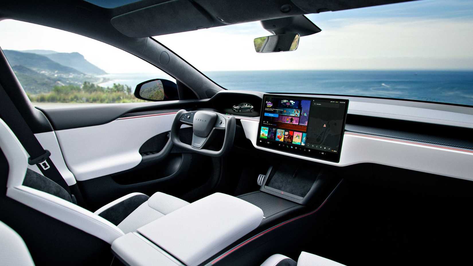 Shot inside the cabin of a Tesla Model S Plaid, showing the front seats, Yoke steering wheel, and infotainment screen.