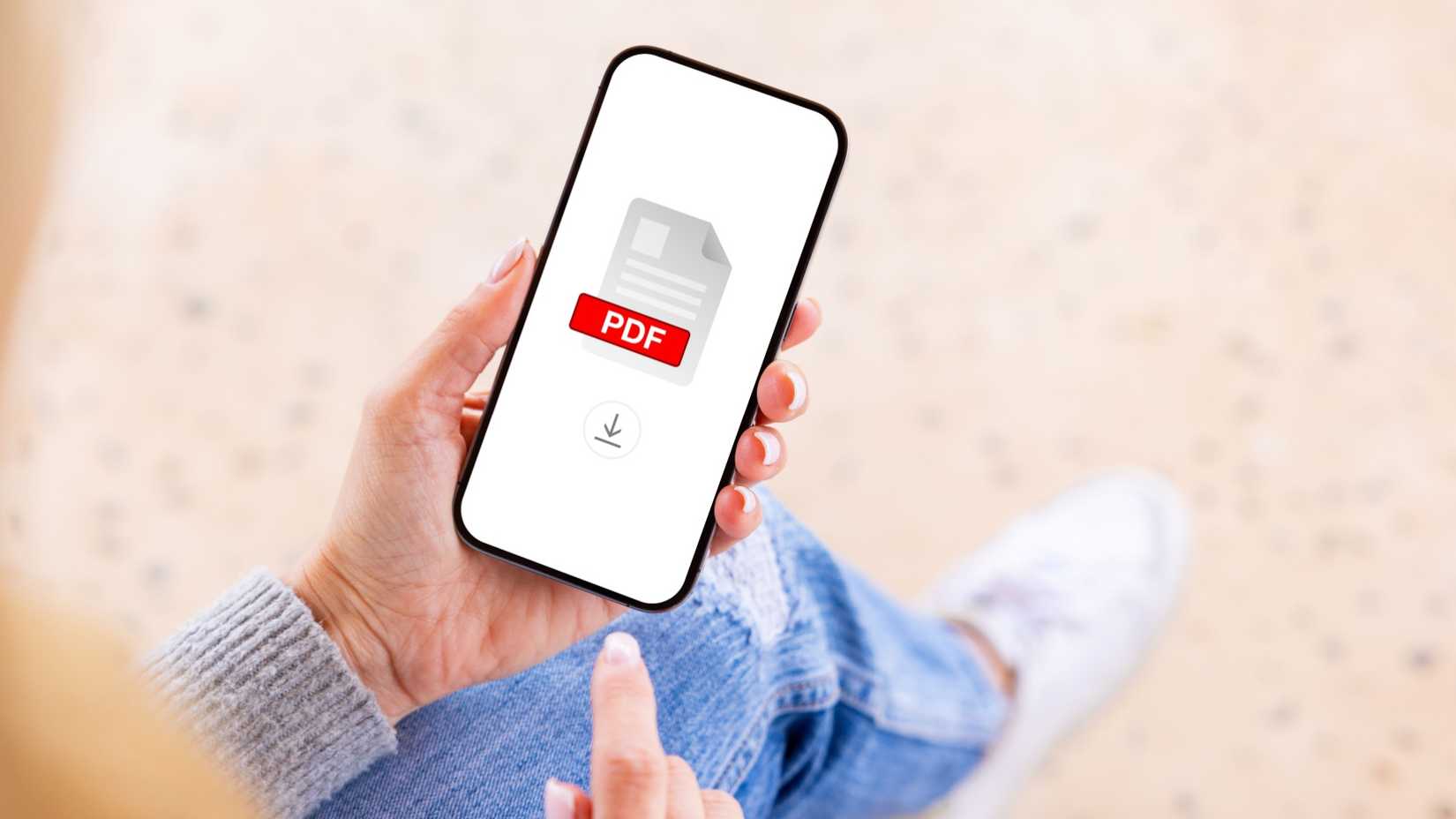 Person holding mobile phone with PDF file icon on the screen.