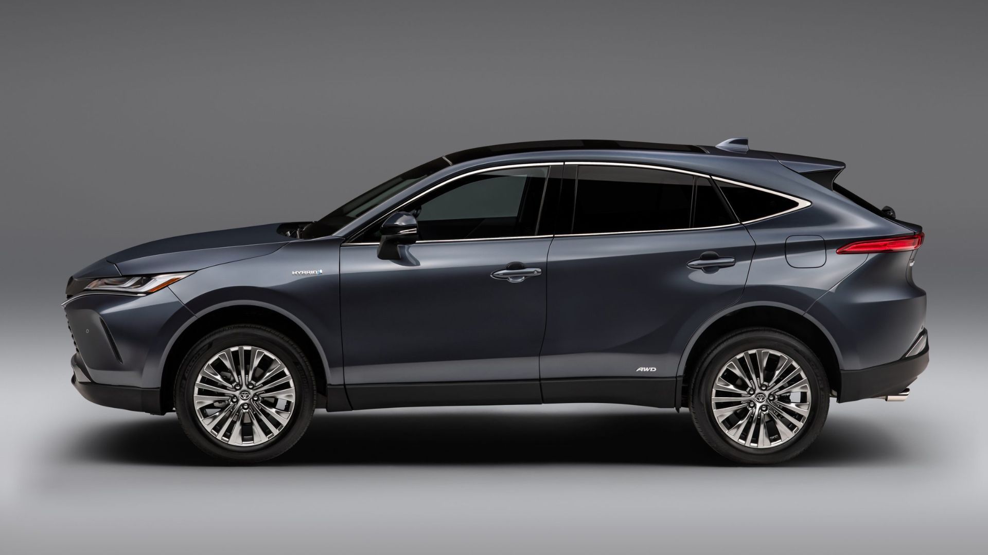 Side profile static shot of a gray 2021 Toyota Venza in studio against a white and gray background.