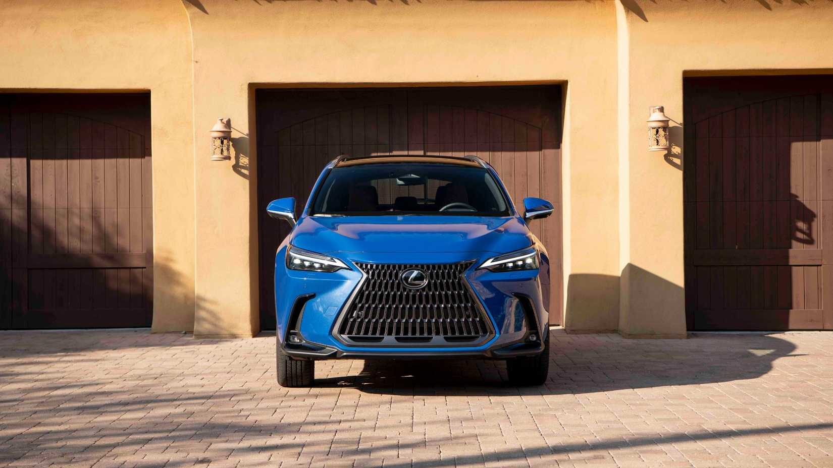 Static front-end shot of a blue 2025 Lexus NX 350h parked outside of a garage.