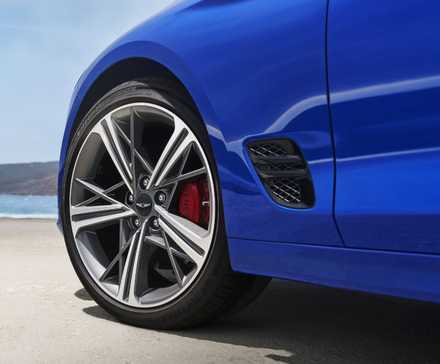 Close-up shot of the alloy wheel on a blue 2025 Genesis G70.