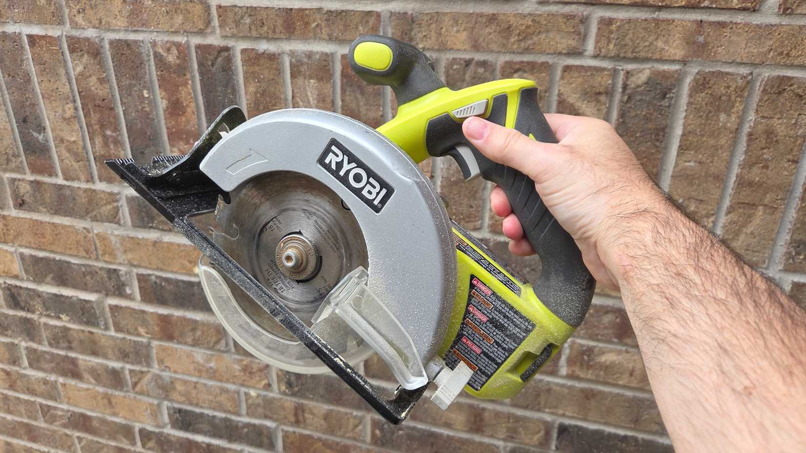 A man holds a circular saw of Riby. 