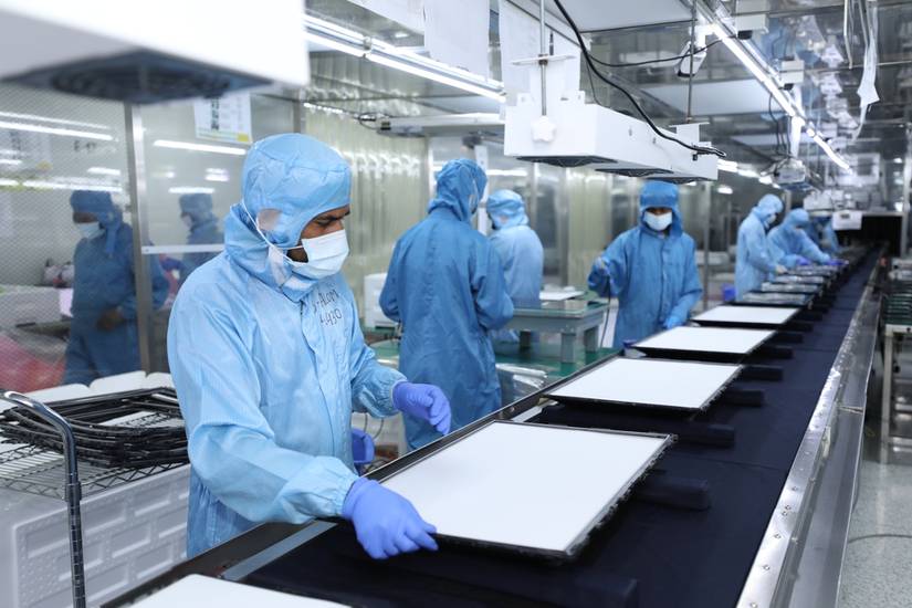 An LCD assembly cleanroom with workers in clean suits.