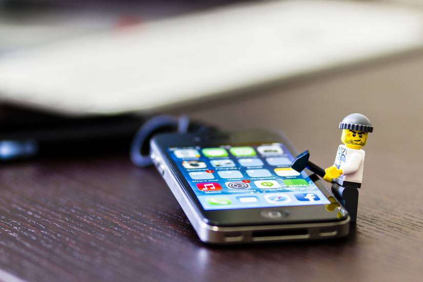 Lego mini figure thief on iPhone breaking in with a hammer. 