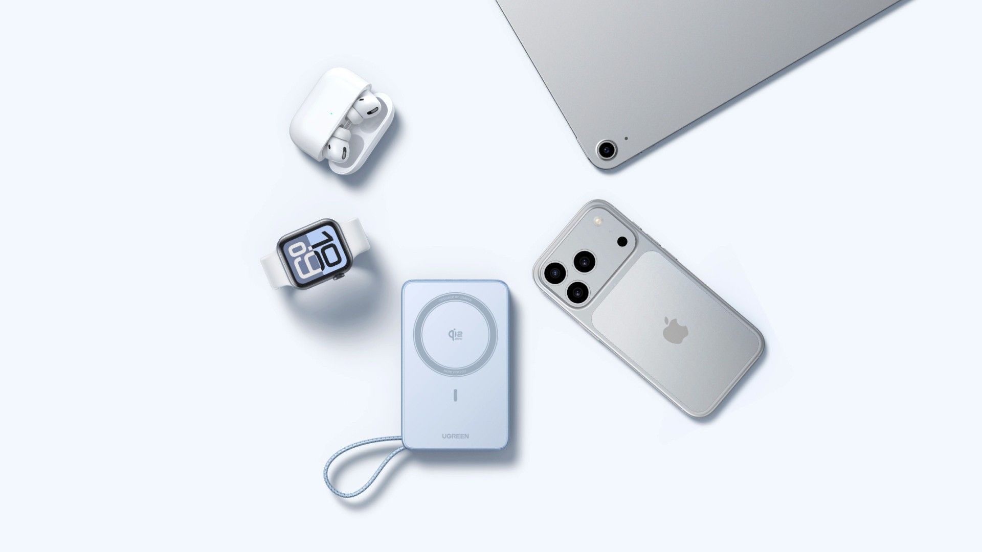 The Ugreen MagFlow Magnetic Power Bank 10000mAh 25W next to an iPhone, an Apple Watch, Airpods, and a Macbook.