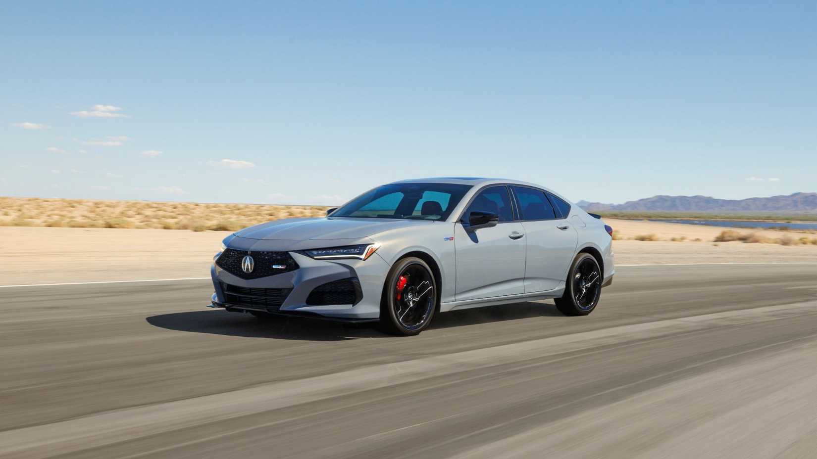 Dynamic front 3/4 shot of a gray 2024 Acura TLX Type S driving on a road through the desert.