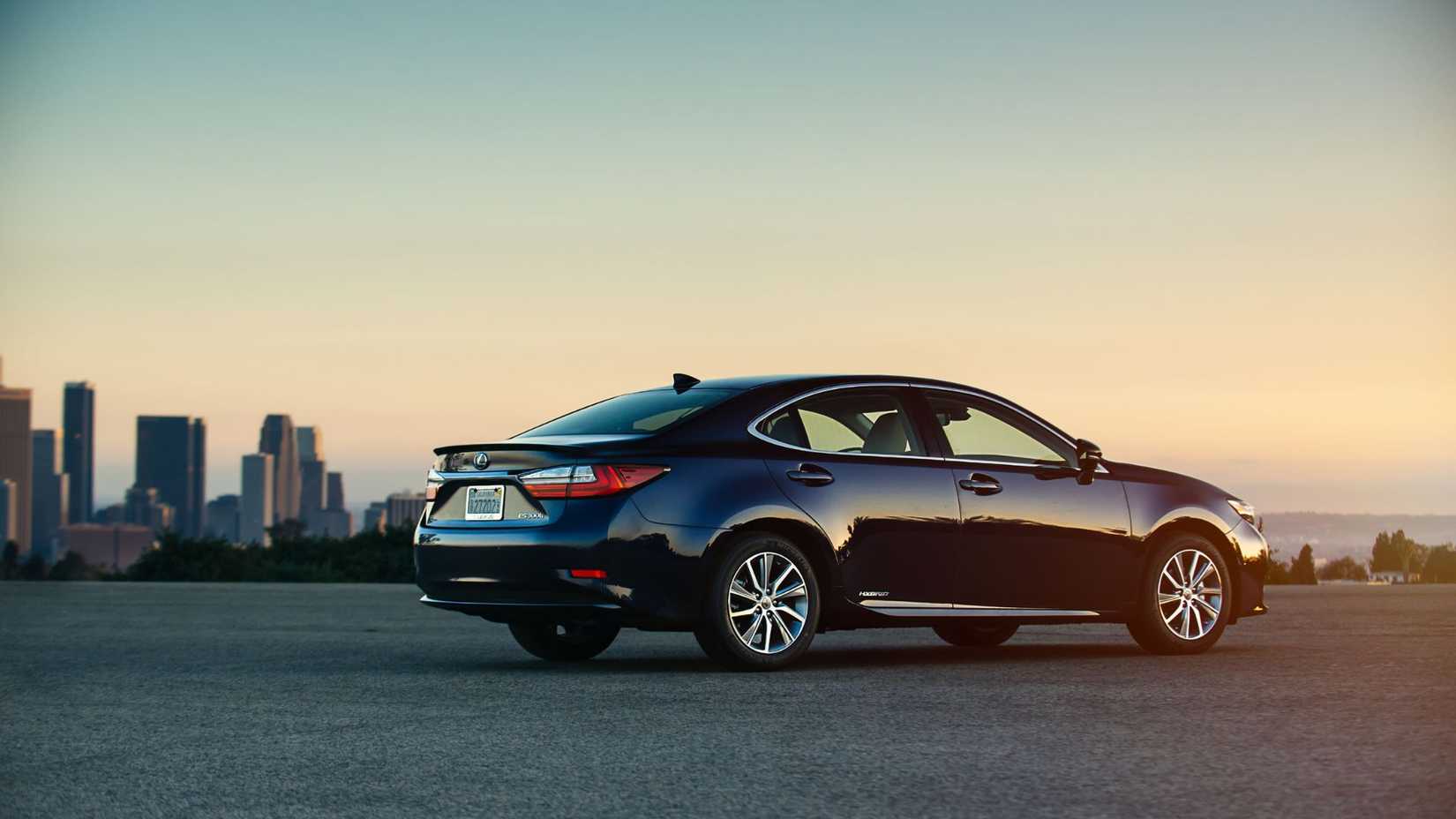 Statci rear 3/4 shot of a black 2018 Lexus ES 300h parked on tarmac with skyscrapers in the background.