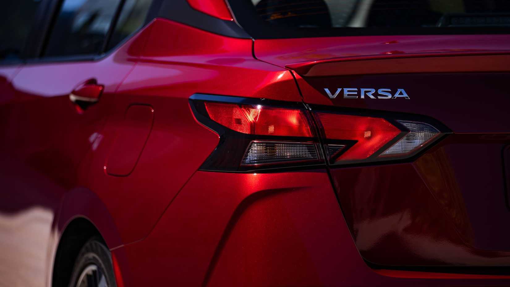 Close-up shot of the badging on the rear of a red 2025 Nissan Versa.