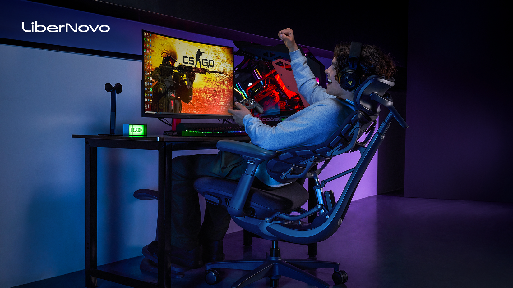 A gamer playing while sitting in a LiberNovo Omni.