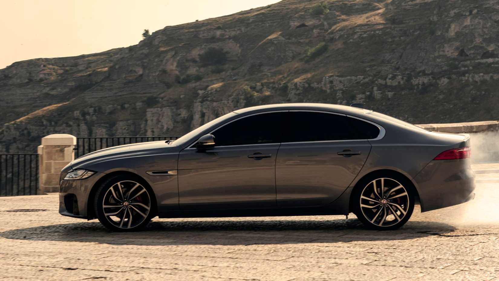 Tiro dinâmico de perfil lateral de um Jaguar XF de 2020, tirado durante as filmagens de No Time To To To To Die de James Bond.