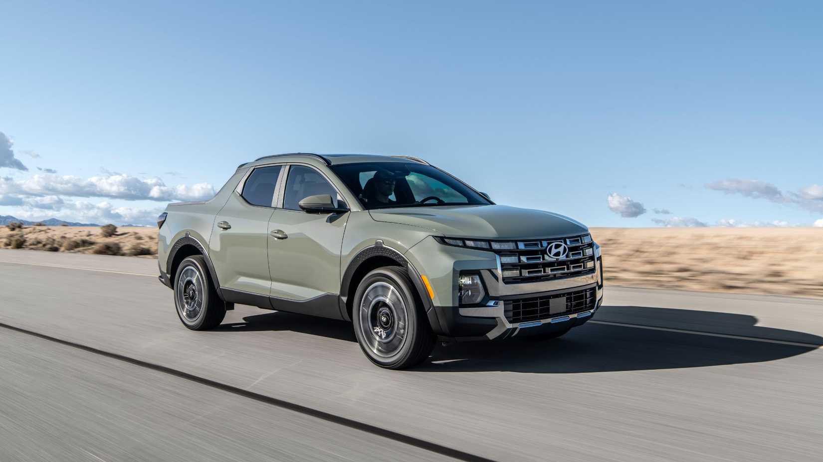 Dynamic front 3/4 shot of a green 2025 Hyundai Santa Cruz Limited driving on a road through the desert.