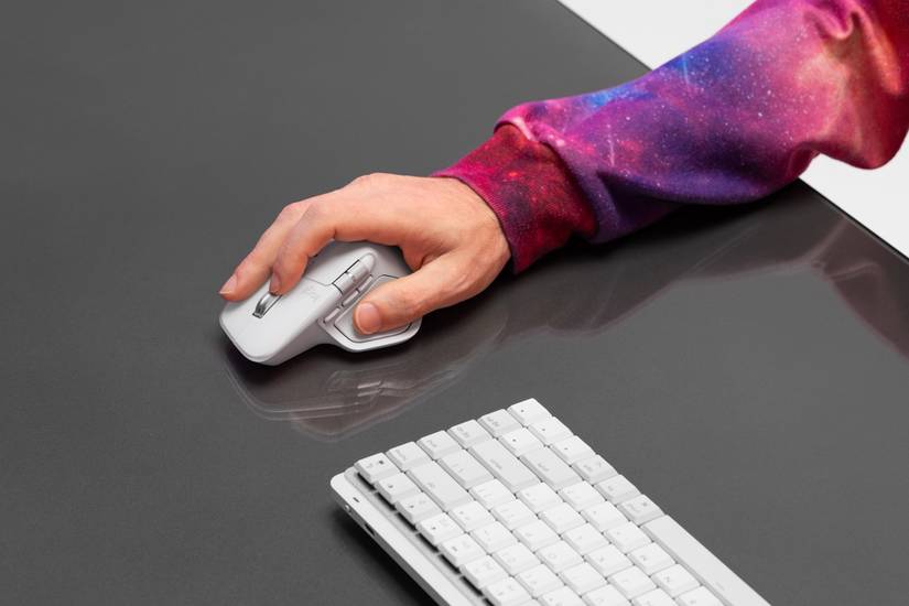 Logitech MX Master 4 on a desk next to a keyboard.