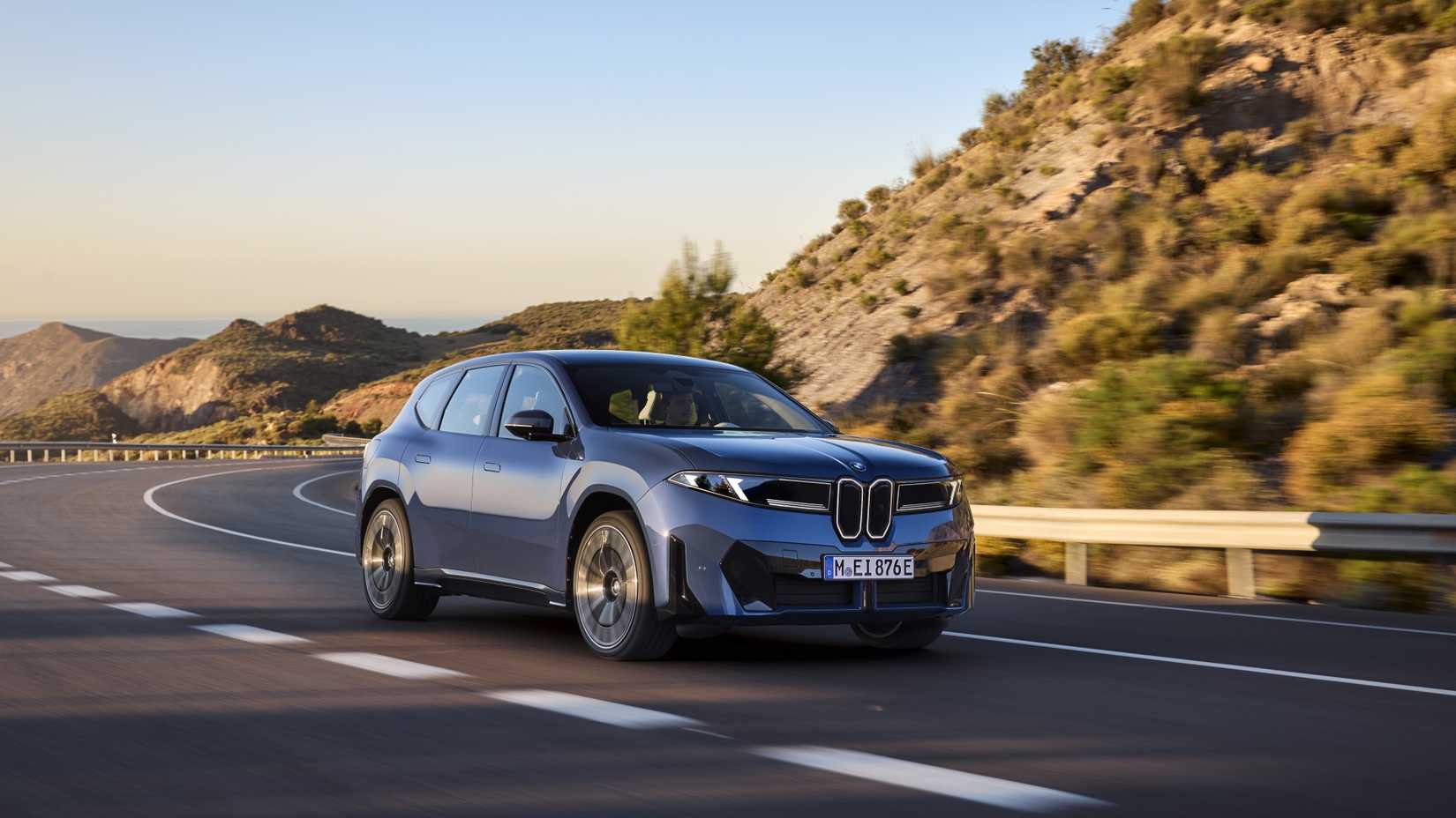 Front 3/4 action shot of a 2026 BMW iX3